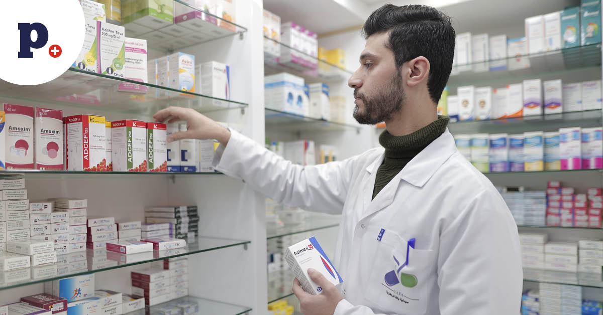 aptekarz między półkami z lekami