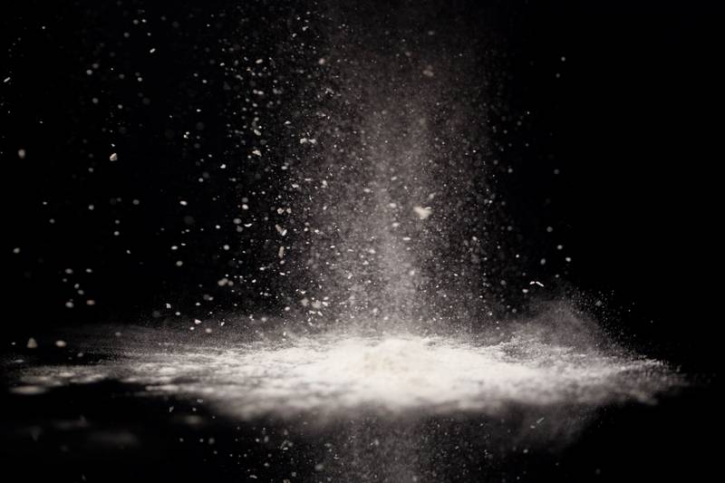 biały proszek spadający na blat