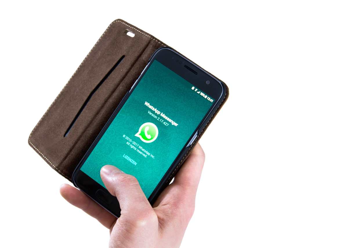 ręka, w niej telefon z aplikacją whatsapp